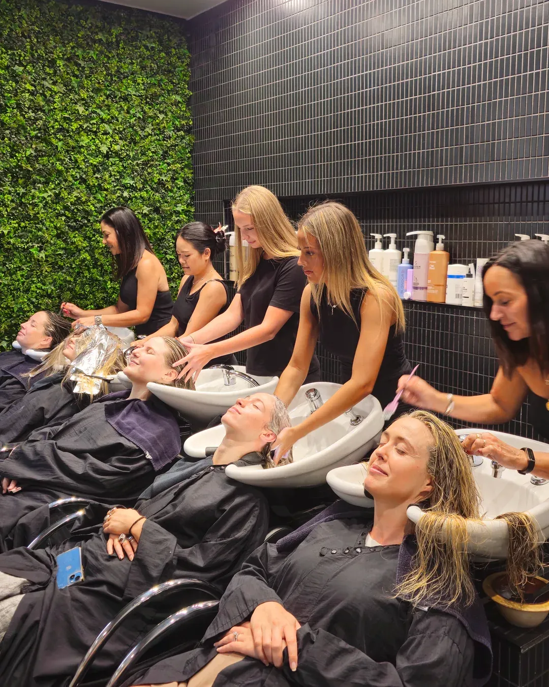 Stylists washing and treating clients' hair at the basins in the Rokk Ebony Malvern salon on Glenferrie Road.