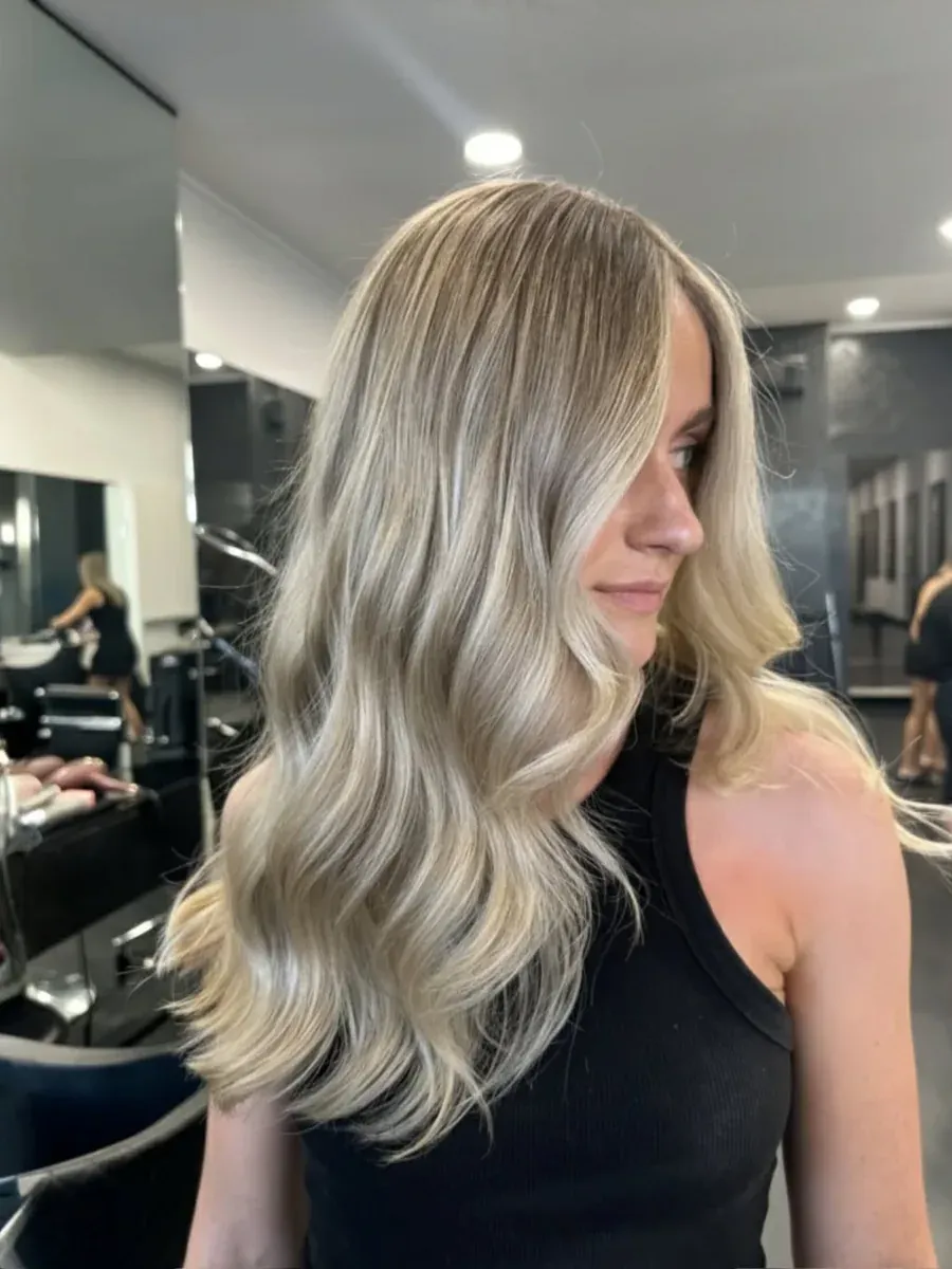 Mid-length blonde balayage with a soft wave, Rokk Ebony Malvern.