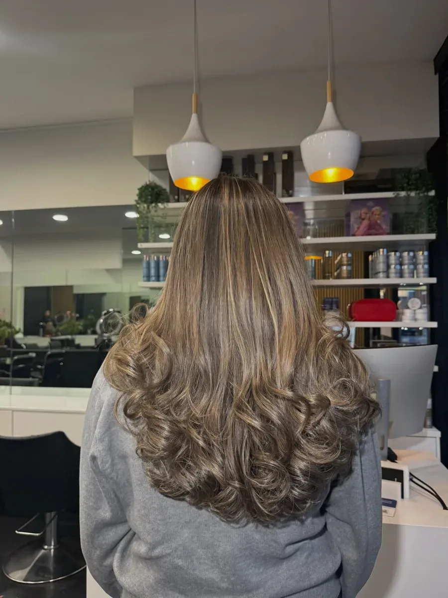 Light brown hair with blonde highlights, finished in a tonged curl, Rokk Ebony Malvern.