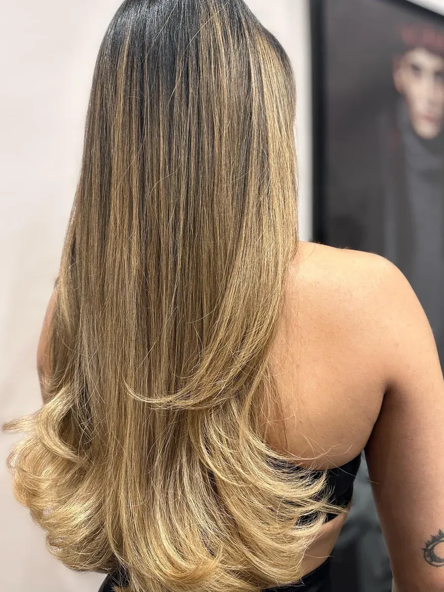 Long hair graduating from a dark root to golden ends, Rokk Ebony Malvern.